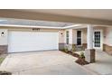 Attached garage and covered driveway feature a brick base and white door at 4087 Clock Tower Dr, Port Orange, FL 32129