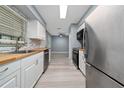 Modern kitchen featuring stainless steel appliances, butcher block countertops and bright white cabinetry, with stylish backsplash at 5 Redwood Trace Run, Ocala, FL 34472