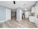 Open-concept kitchen flows into the living area, featuring stainless steel appliances and seamless flooring throughout at 5 Redwood Trace Run, Ocala, FL 34472