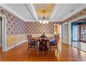 Dining room features an octagon table, hardwood floors, and decorative wallpaper and ceiling at 525 Sheridan Blvd, Orlando, FL 32804