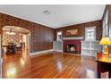 Spacious living room with hardwood floors, a brick fireplace, built-in bookshelves, and an inviting atmosphere at 525 Sheridan Blvd, Orlando, FL 32804