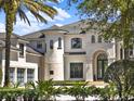 Close up of an elegant two-story home with arched entryway and well-maintained landscaping at 6137 Grosvenor Shore Dr, Windermere, FL 34786