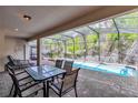 Enclosed pool and patio area, featuring a table with seating for four and several lounge chairs at 8840 Bengal Ct, Kissimmee, FL 34747