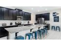Modern kitchen featuring stainless steel appliances, a large island with seating, and sleek cabinetry at 9004 Sunshine Ridge Loop, Kissimmee, FL 34747