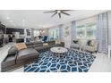 Bright living room featuring a modern ceiling fan, stylish furniture, and sliding glass doors at 9004 Sunshine Ridge Loop, Kissimmee, FL 34747