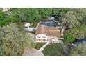 Aerial view of a home featuring a screened-in pool, outbuildings, and mature trees at 1204 Swan St, Winter Springs, FL 32708
