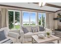 Bright living room featuring large windows with water views, comfortable seating, and elegant decor at 3168 S Peninsula Dr, Daytona Beach, FL 32118
