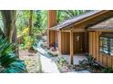 A cozy home features a tranquil walkway surrounded by mature landscaping and a covered entryway at 1 W Village Dr, Oviedo, FL 32765