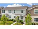 Exterior showcasing a neat lawn and neutral-tone facade with stylish architectural detail at 10684 Words Dr, Winter Garden, FL 34787
