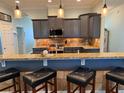 Modern kitchen featuring granite countertops, stone backsplash, dark gray cabinets, and pendant lighting at 12238 Still Meadow Dr, Clermont, FL 34711