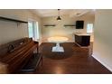 Bright dining area with wood floors, adjacent to kitchen bar, and an vintage piano at 1528 Baltimore Dr, Orlando, FL 32810