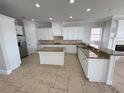 Open kitchen with island, white cabinetry, and granite countertops at 1554 Corolla Ct, Reunion, FL 34747