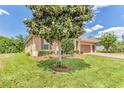 Beautiful home exterior featuring a large magnolia tree, green lawn, and a two-car garage at 2724 Westyn Cove Ln, Ocoee, FL 34761