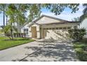 Inviting front exterior showcasing a spacious driveway and well-maintained landscaping at 300 Augustine Ct, Oviedo, FL 32765