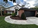 Beautiful home with brick accents, a well-manicured lawn, and a black two-car garage at 3063 Ash Park Loop, Winter Park, FL 32792
