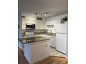 Bright kitchen with white cabinets, stone countertops, and modern appliances at 315 Lakepointe Dr # 201, Altamonte Springs, FL 32701