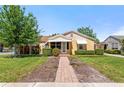 Charming single-story home with a well-manicured lawn and inviting brick walkway, with awning covered front porch at 335 W Bay St, Winter Garden, FL 34787