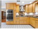 A beautifully designed kitchen featuring stainless steel appliances, granite countertops, and custom wood cabinets at 335 W Bay St, Winter Garden, FL 34787