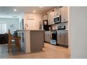 Modern kitchen with gray cabinets, stainless steel appliances, and a breakfast bar at 33891 Sky Blossom Cir, Leesburg, FL 34788
