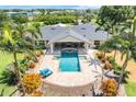 Aerial view of a beautiful backyard featuring a large swimming pool, bar area, and lush landscaping with palm trees at 3640 Crump Rd, Winter Haven, FL 33881