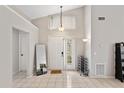 Bright entryway with high ceilings, tile flooring, a front door with sidelights, and a decorative chandelier at 3830 Spring Breeze Dr, Orlando, FL 32829
