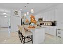 Modern kitchen featuring white cabinetry, stainless steel appliances, and a center island with seating at 4569 Cabello Loop, Kissimmee, FL 34746