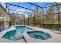 Private screened-in pool and spa with beautiful tile work, surrounded by lush landscaping at 4569 Cabello Loop, Kissimmee, FL 34746