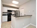 Open concept kitchen featuring a breakfast bar, stainless steel appliances, and ample storage space at 5578 Metrowest Blvd # 10, Orlando, FL 32811