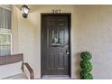 Dark front door with a 'welcome' sign, topiary, and a partial view of porch seating at 623 Dory Ln # 307, Altamonte Springs, FL 32714