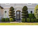 Beautifully landscaped front entrance with decorative shrubbery and a glass-paneled door at 645 American Holly Pl, Oviedo, FL 32765