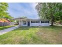 Single-story home with a well-manicured lawn, covered parking, and black window shutters at 73 Channing Ave, Orlando, FL 32811