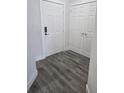Hallway with gray wood-look flooring, a front door, and a coat closet at 8775 Sartori St # 302, Orlando, FL 32829