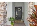 Elegant front entry with stone pillars, a decorative wreath, and a 'Welcome' sign at 944 Flyer St, Orange City, FL 32763