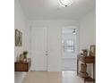 Inviting entryway featuring neutral tile flooring, white walls, and decor-enhancing wooden furniture at 1030 Alabaster Way, Deltona, FL 32725