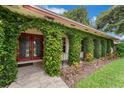 Close-up of ivy-covered arches leading to red front doors and a tiled porch at 222 Yarmouth Rd, Fern Park, FL 32730
