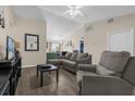 Comfortable living area with hardwood-style flooring, neutral walls, gray sofa, and access to the kitchen at 335 Snook Way, Poinciana, FL 34759