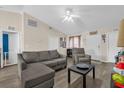 Inviting living room featuring a plush gray sectional sofa, modern ceiling fan, and neutral wall colors at 335 Snook Way, Poinciana, FL 34759