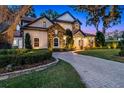 Beautiful exterior of a two-story stucco and stone home with a tile roof and paver driveway at 805 W 2Nd Ave, Windermere, FL 34786