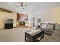 Bright living room with stone fireplace, complemented by neutral carpet and a cozy couch at 1037 Parnell Ct, Deltona, FL 32738