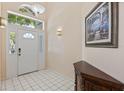 Bright foyer with a white front door, transom window, tile flooring, and accent furniture at 408 Lexingdale Dr, Orlando, FL 32828