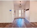 Bright foyer with wood-look floors, a chandelier, and a front door with decorative glass at 7808 The Esplanade Ct, Orlando, FL 32836