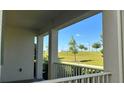 Picturesque porch view of a lush green lawn and trees under a clear blue sky at 11015 Bostwick Aly, Winter Garden, FL 34787