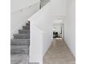 Bright entryway featuring neutral flooring, carpeted stairs, and white walls for a modern and clean look at 1179 Tyler Loop, Winter Haven, FL 33884