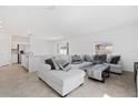 Open-concept living area featuring a large sectional sofa and neutral tile floors for a bright and airy feel at 1179 Tyler Loop, Winter Haven, FL 33884