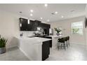 Bright kitchen boasting a large island, sleek black cabinets, and modern pendant lighting at 12180 Sonnet Ave, Orlando, FL 32832