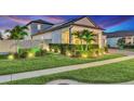 Landscaped yard and exterior of a home with decorative lighting and lush green foliage at 13202 Spring Grove Way, Winter Garden, FL 34787