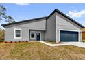 Attractive single-story home with a gray exterior, a blue front door, and an attached garage at 13673 Sw 43 Cir, Ocala, FL 34473