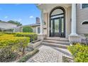 Close up of the home's beautiful arched doorway, trimmed with columns, and surrounding well maintained landscaping at 1370 Alberta Dr, Winter Park, FL 32789