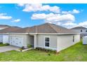 Well-maintained home showcasing its side exterior, two-car garage, green lawn, and fresh landscaping at 1511 Finnigan Cir, Haines City, FL 33844