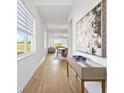Bright hallway with wood flooring, an elegant table, and an eye-catching painting on the wall at 15750 Vetta Dr, Montverde, FL 34756